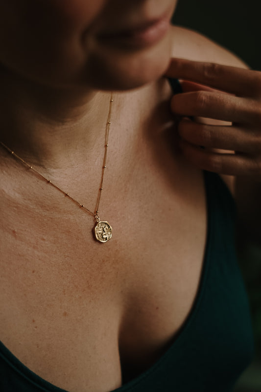 Verspieltes Blumen-Amulett aus Edelstahl mit zartem Blütendesign, ideal für Sommer-Looks und feminine Outfits.